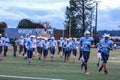 Boys football squad runs on the field with pink socks to support breast cancer awareness