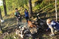 Boys fry sausages over fire in forest Royalty Free Stock Photo