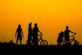 Boys and girls standing behind a bike with sunset Silhouette Concept Royalty Free Stock Photo