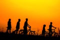 Boys and girls standing a bike with sunset Silhouette concept Royalty Free Stock Photo