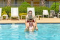 Boys have fun playing piggyback in the pool Royalty Free Stock Photo