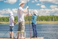 Boys with his father on the pier while fishing Royalty Free Stock Photo