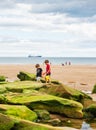 Boys holding buckets playing at King Edward`s Bay beach on a hot