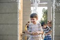 Boys jumping in water fountains. Children playing with a city fountain on hot summer day. Happy friends having fun in fountain. Royalty Free Stock Photo