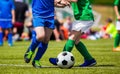 Boys kicking football match on the sports field. Kids soccer teams compete in the school soccer tournament