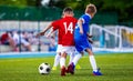 Boys Kicking Soccer Ball on Grass Pitch. Children Football Players