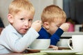 Boys kids children eating corn flakes breakfast meal at the table Royalty Free Stock Photo
