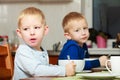 Boys kids children eating corn flakes breakfast meal at the table Royalty Free Stock Photo