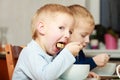 Boys kids children eating corn flakes breakfast meal at the table Royalty Free Stock Photo