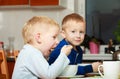 Boys kids children eating corn flakes breakfast meal at the table Royalty Free Stock Photo