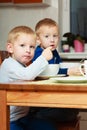 Boys kids children eating corn flakes breakfast meal at the table Royalty Free Stock Photo