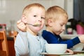 Boys kids children eating corn flakes breakfast meal at the table Royalty Free Stock Photo