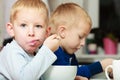 Boys kids children eating corn flakes breakfast meal at the table Royalty Free Stock Photo