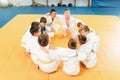 Boys in kimono sitting on the floor, judo training