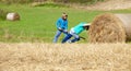 Boys Moving Bale of Hay with Stick as a Lever