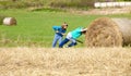 Boys Moving Bale of Hay with Stick as a Lever