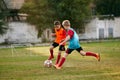 Boys payers wearing sport uniform playing soccer. Competition between players running and kicking football ball Royalty Free Stock Photo