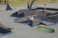 Boys perform tricks on a skateboard and scooter in the arena for extreme sports