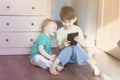 Boys play in tablet together laughing.