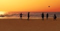 Boys are playing a ball on the beach