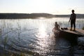 Boys playing on wooden bridge by lake Royalty Free Stock Photo