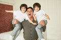 Boys. Portrait of happy latin family, cheerful father holding little twins and smiling at camera while posing, having