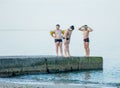 The boys are preparing to jump from the pier into the sea