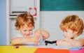 Boys Pupils from elementary school drawing at the school. Cheerful smiling little pupils having fun. Happy cute clever