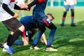 Boys in red and blue sportswear plays football on field, dribbles ball. Young soccer players with ball on green grass. Royalty Free Stock Photo