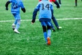 Boys in red and blue sportswear plays soccer on green grass field. Youth football game. Children sport competition Royalty Free Stock Photo