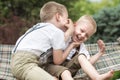 The two brothers rest,telling secrets in his ear.Boys ride in the hammock. Royalty Free Stock Photo