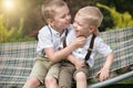 The two brothers rest,telling secrets in his ear.Boys ride in the hammock. Royalty Free Stock Photo