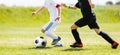 Boys Running After the Ball on Green Grass. Footballers in White and Black Shirts