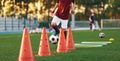 Boys running soccer balls between training cones. European football sports summer camp for youth athletes Royalty Free Stock Photo