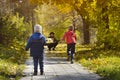 Boys running towards her mother. Autumn Park. Back view