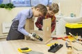 Boys with screwdrivers and drill repairing wooden stool