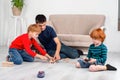 The boys sit on the floor in the room and play with the machine with the remote control Royalty Free Stock Photo
