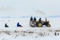 Boys are sledding thanks to tractor.