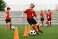 Boys on soccer football training. Young players dribble ball between training cones. Soccer summer training camp. Players on