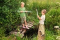 Boys with sticks battling for fun on bridges Royalty Free Stock Photo