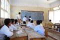 2 boys students in classroom writing on blackboard