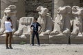 Boys take photographs in front of stone carved ram statues at the Temple of Karnak in Luxor in Egypt.
