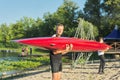 Boys teenagers walking with sports boat kayaking to river