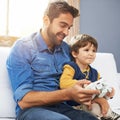 Boys and their toys. a father and his young son playing video games. Royalty Free Stock Photo