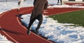 Boys track team running on track with snow Royalty Free Stock Photo