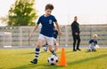 Boys training football dribbling in a field. Kids Running the Ball. Players develop soccer dribbling skills