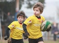 Boys, under 8 aged, yellow jacket play rugby Royalty Free Stock Photo