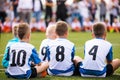 Boys wearing white soccer jersey shirts with black numbers on back