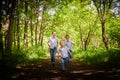 Boys in a white shirts and a pink butterfly in nature among the greenery. Funny walk of three brothers in the park or forest