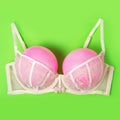 Bra with pink balloons on a green background. Fun, conceptual photo, great big breasts. Complementary colors Royalty Free Stock Photo